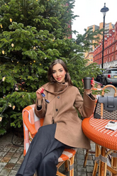 a lady in a brown coat and a pair of black pants